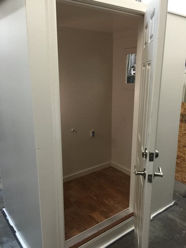 Empty white room with a door and window, showcasing minimal interior design.