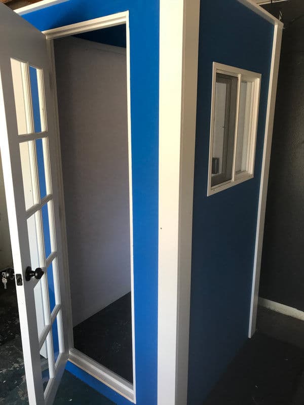 Modern blue outdoor storage shed with a white door and window, showcasing a sleek design.