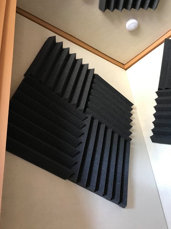 Acoustic foam panels installed on walls for soundproofing in a recording studio.