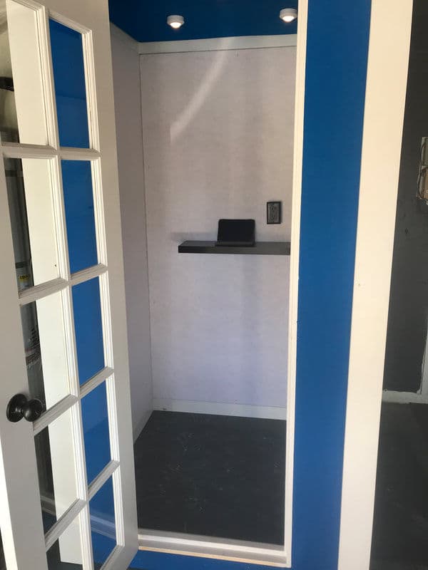 Modern closet with blue walls, white trim, and a small shelf inside.