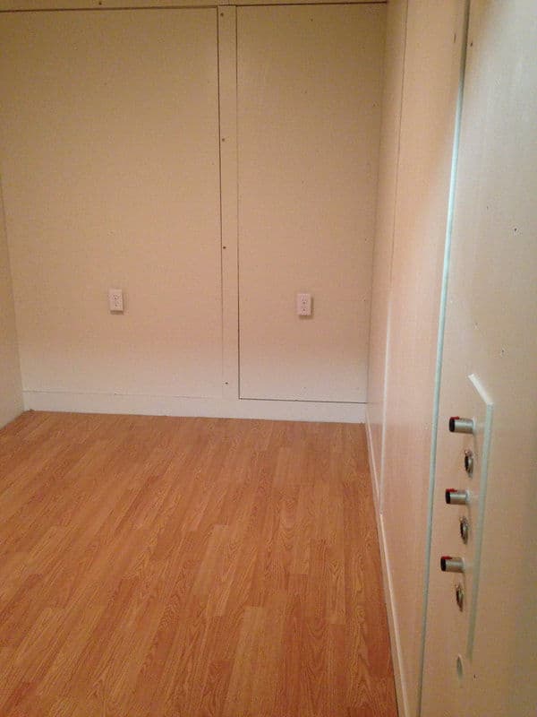 Empty room with light wood flooring, white walls, and electrical outlets visible.