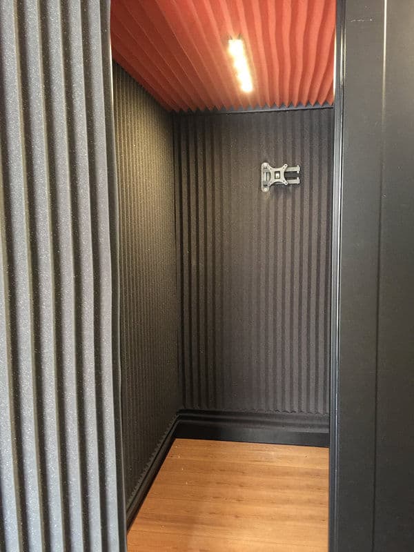 Interior of a soundproof room with acoustic panels and warm lighting.