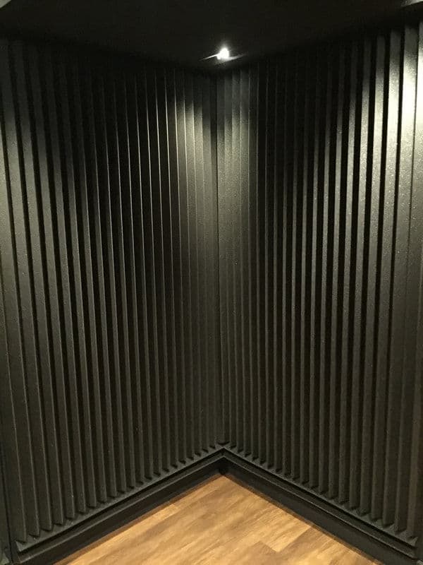 Soundproof recording studio corner with acoustic foam panels and subtle lighting.