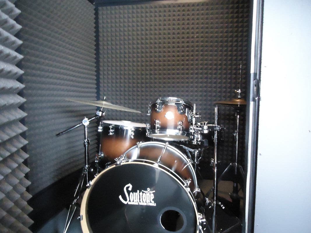 Drum set in a soundproof studio with black acoustic foam walls.