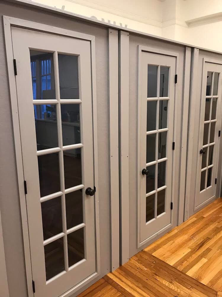 Gray sliding doors with glass panels in a modern interior setting.