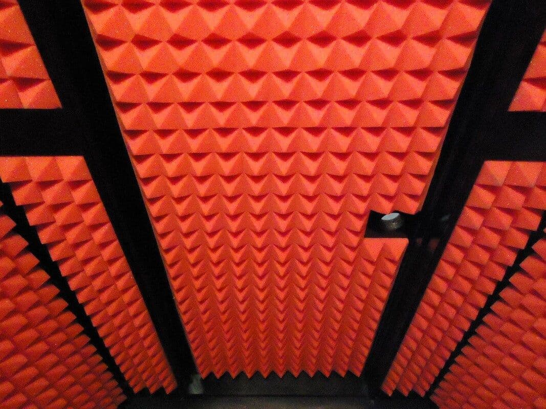 Acoustic foam panels in red pyramid design for soundproofing and noise reduction.